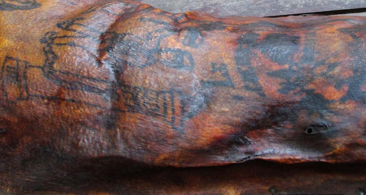 Tattoos reveal secrets of man whose flayed skin was nailed to a board