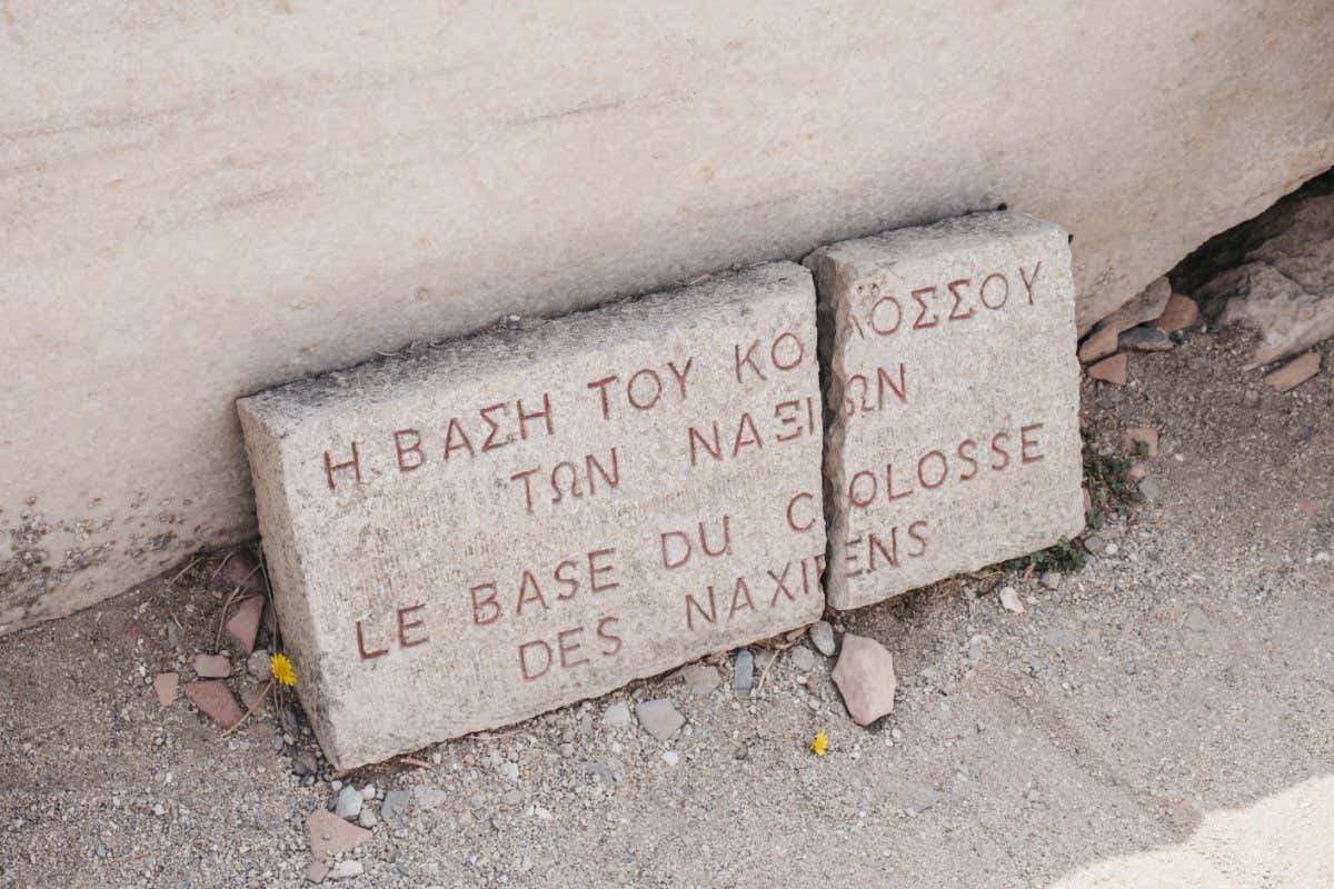 Close up of the Le Base du Colosse des Naxiens ("The Base of the Colossus of the Naxians") sign on the island of Delos, Greece, an archaeological site near Mykonos in the Aegean Sea.; Shutterstock ID 1527968039; purchase_order: -; job: -; client: -; other: -