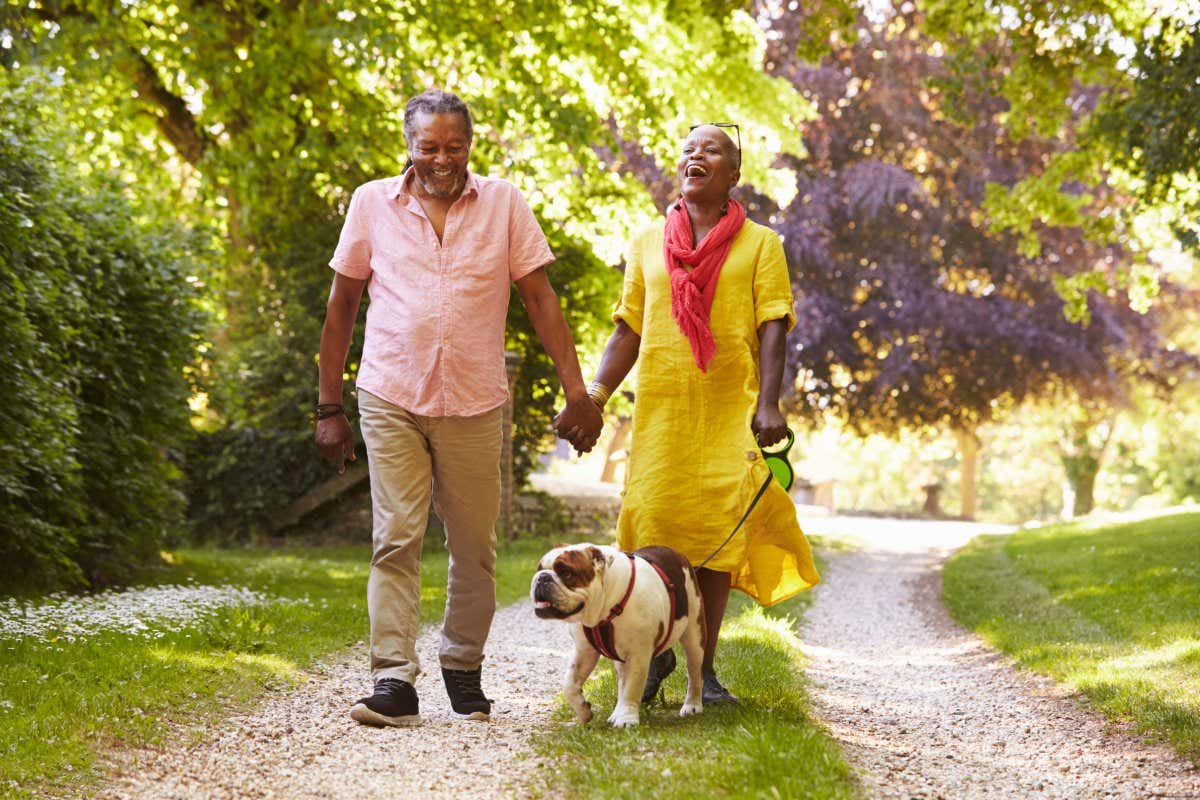Senior Couple Walking With Pet Bulldog In Countryside; Shutterstock ID 755507464; purchase_order: -; job: -; client: -; other: -