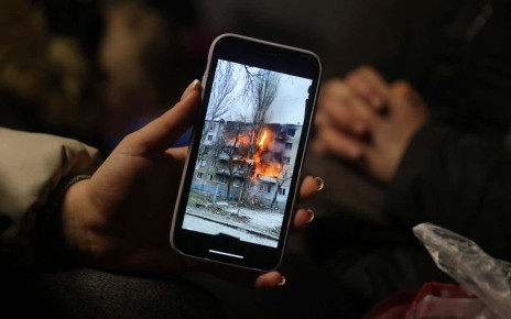 MEDYKA, POLAND - MARCH 09: Iryna Holoshchapova, a Ukrainian refugee who fled the embattled city of Mykolaiv, shows a video on her smartphone of a friend's apartment block in Mykolaiv on fire following a Russian attack as she, her son Tibor and mother Halina rest in a heated tent at the Medyka border crossing on March 09, 2022 in Medyka, Poland. Yulia said her friend was not in the building when it was struck. Over one million people have arrived in Poland from Ukraine since the Russian invasion of February 24, and while many are now living with relatives who live and work in Poland, others are journeying onward to other countries in Europe. (Photo by Sean Gallup/Getty Images)
