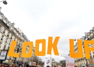 Protesters hold placards during a &quot;Look up&quot; march, to call on the presidential candidates to take into account the climate emergency, which protesters say is largely absent from the election campaign, less than two weeks after a warning from UN climate experts and a month before the presidential election, in Paris on March 12, 2022. - According to the organisers, nearly 150 marches are expected to take place across France, supported by NGOs, associations or other groups. The protests are dubbed &quot;Look up&quot; in reference to the film &quot;Don't look up&quot;, a metaphor for the climate crisis that has been a hit on Netflix. (Photo by Alain JOCARD / AFP) (Photo by ALAIN JOCARD/AFP via Getty Images)