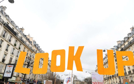 Protesters hold placards during a &quot;Look up&quot; march, to call on the presidential candidates to take into account the climate emergency, which protesters say is largely absent from the election campaign, less than two weeks after a warning from UN climate experts and a month before the presidential election, in Paris on March 12, 2022. - According to the organisers, nearly 150 marches are expected to take place across France, supported by NGOs, associations or other groups. The protests are dubbed &quot;Look up&quot; in reference to the film &quot;Don't look up&quot;, a metaphor for the climate crisis that has been a hit on Netflix. (Photo by Alain JOCARD / AFP) (Photo by ALAIN JOCARD/AFP via Getty Images)