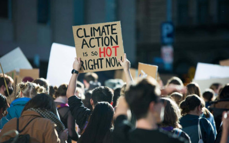 &quot;Climate Action is so hot right now&quot; text written on a sign at student climate change protest in Melbourne Australia. Group of protesters marching down street against global warming. Focus on sign.; Shutterstock ID 1992990047; purchase_order: -; job: -; client: -; other: -