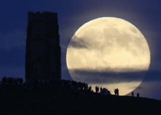 GLASTONBURY, ENGLAND - JUNE 20: A full moon rises behind Glastonbury Tor as people gather to celebrate the summer solstice on June 20, 2016 in Somerset, England. Tonight's strawberry moon, a name given to the full moon in June by Native Americans because it marks the beginning of strawberry picking season, last occurred on the solstice on June 22, 1967 and it will not happen again on the summer solstice for another 46 years until June 21, 2062. (Photo by Matt Cardy/Getty Images)
