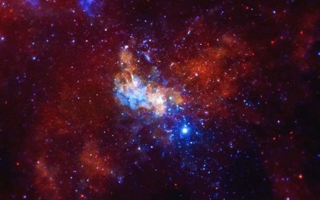 An image of an area of space filled with red and blue gas, and scattered stars