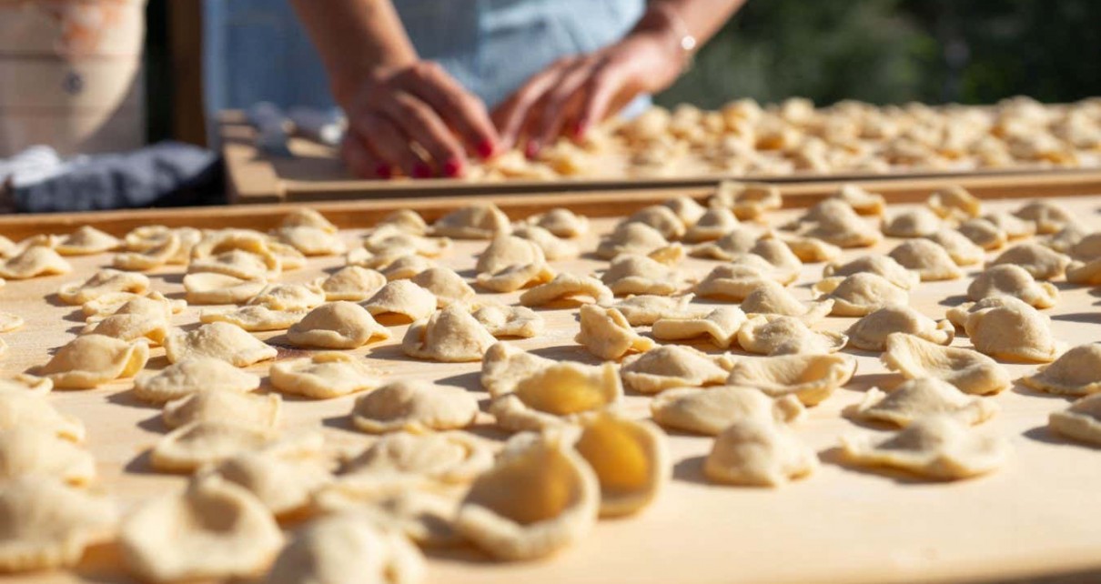 Ostuni, Puglia, Italy - 05 20 2022: Preparation of typical handmade pasta called "Orecchiette" in an outdoor space during the sunset light; Shutterstock ID 2158414957; purchase_order: -; job: -; client: -; other: -