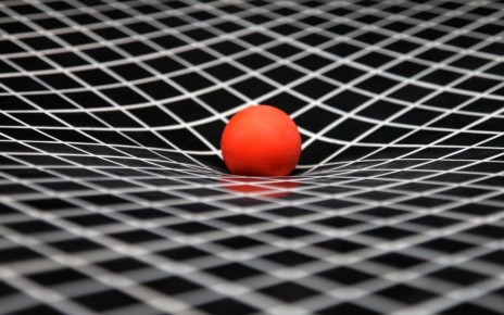 A simulation of gravity showing curved space-time. The ball represents the sun and is resting on a sheet of plastic that stretches under its weight. The curved sheet of plastic demonstrates the way a gravity curves space.
