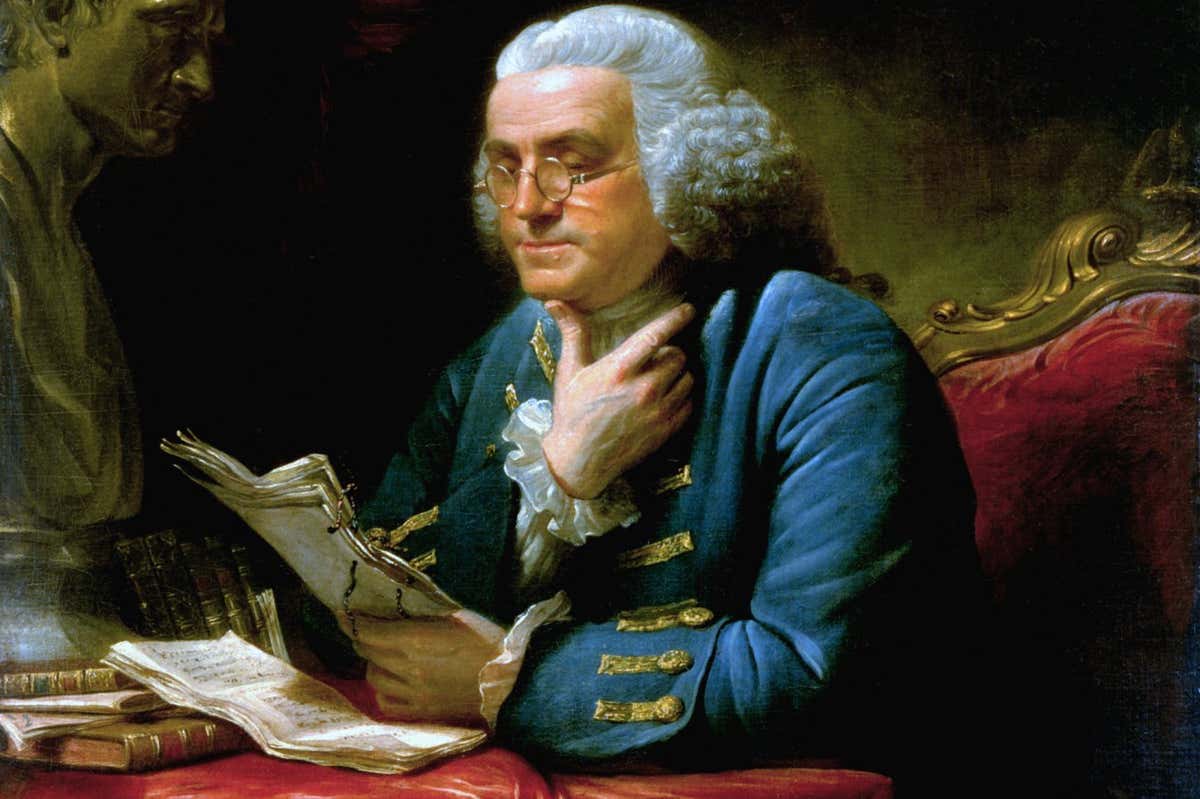 A painting of Benjamin Franklin (1706-1790), one of the Founding Fathers of the United States, in London, 1767, wearing a blue suit with elaborate gold braid and buttons, a far cry from the simple dress he affected when he served as ambassador to France in later years. During his time in London, Franklin was the leading voice of American interests in England. He wrote popular essays on behalf of the colonies and was instrumental in securing the repeal of the 1765 Stamp Act. The painting is by David Martin and is currently on display in the White House. The bust on the left side is that of Isaac Newton. (Photo by: Pictures From History/Universal Images Group via Getty Images)