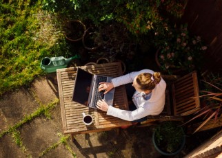 UK, Essex, Harlow, elevated view of a woman working from home in her garden using a laptop computer