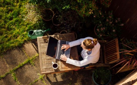 UK, Essex, Harlow, elevated view of a woman working from home in her garden using a laptop computer