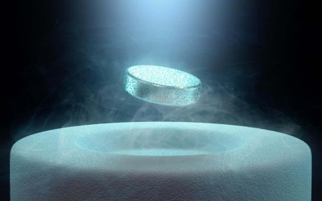 E8X75D Image concept of magnetic levitating above a high-temperature superconductor, cooled with liquid nitrogen.