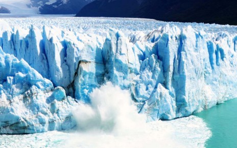 A huge chunk of glacier ice collapsing and falling into the sea