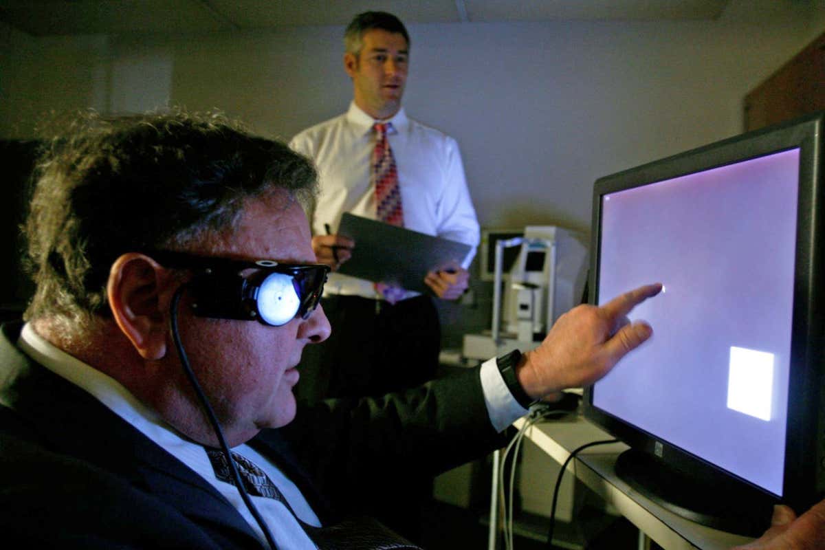 2R61H1F Dean Lloyd (left) uses a touch screen monitor to test his Argus II eye implant at UCSF Medical Center in San Francisco, Calif., on Friday, Feb. 27, 2009. Neuroscientist Matthew McMahon monitors Lloyd's progress. Lloyd, who has been completely blind for several years, can now see rough images of shapes and colors thanks to the experimental implant developed by Second Sight. (Paul Chinn/San Francisco Chronicle via AP)