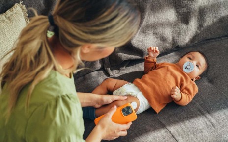 A baby wearing a sensor for measuring blood glucose levels