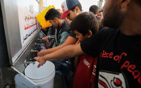 Palestinians line up to fill water cannisters in Gaza