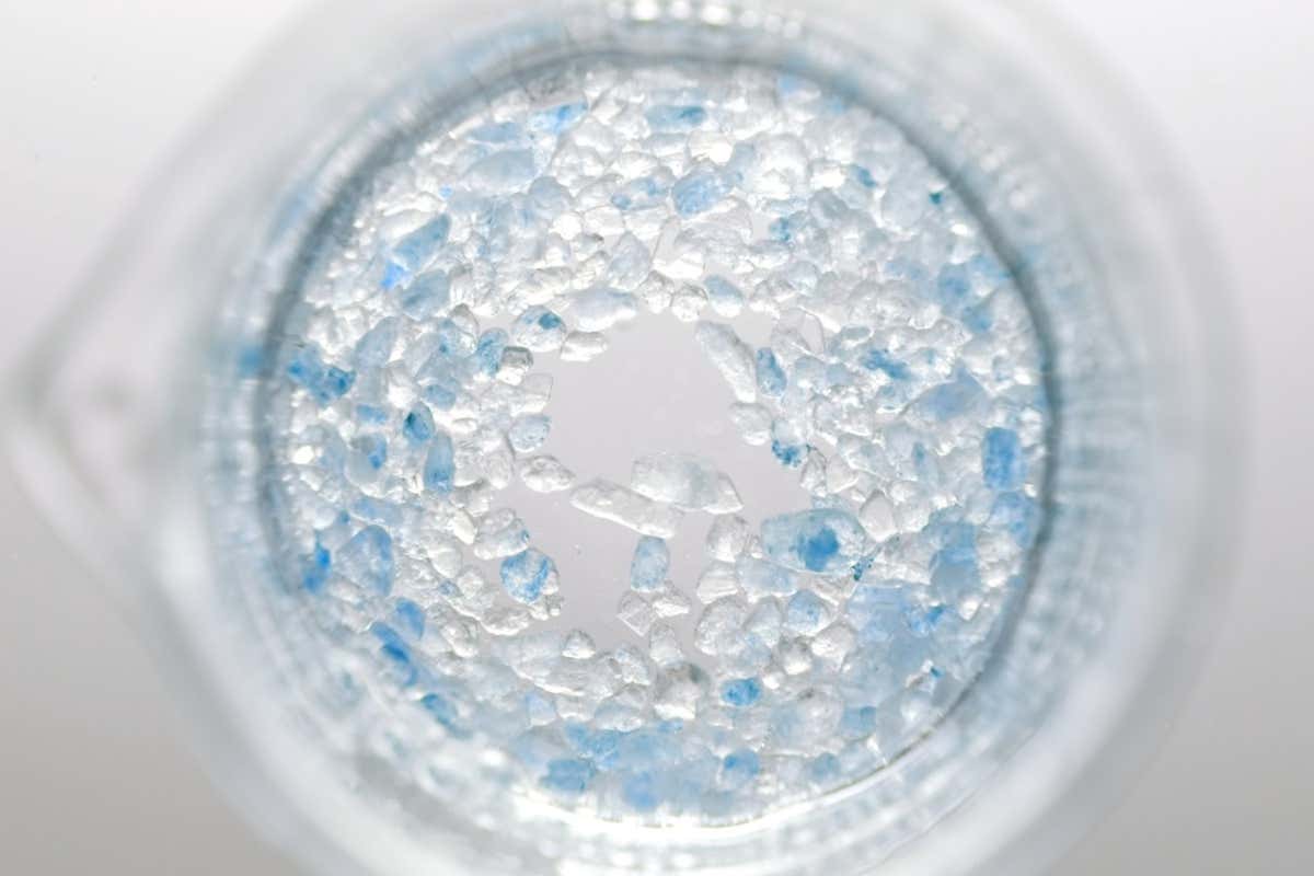 salt crystals dissolving in beaker with water
