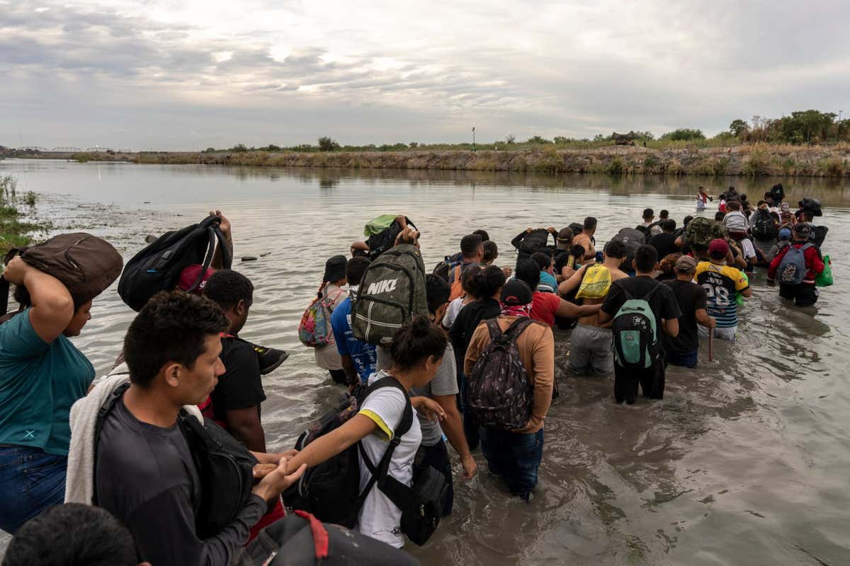 Migrants cross the Rio Grande at the US-Mexico border in Piedras Negras, Coahuila state, Mexico, on Friday, Oct. 6, 2023. Mexico, along with President??Joe Biden's administration and the??United Nations, is considering setting up a temporary program to help pre-screen tens of thousands of migrants for US entry eligibility as border crossings increase again. Photographer: Alejandro Cegarra/Bloomberg via Getty Images