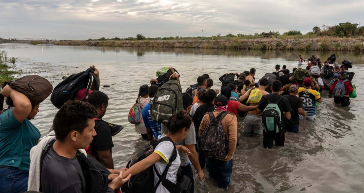 Migrants cross the Rio Grande at the US-Mexico border in Piedras Negras, Coahuila state, Mexico, on Friday, Oct. 6, 2023. Mexico, along with President??Joe Biden's administration and the??United Nations, is considering setting up a temporary program to help pre-screen tens of thousands of migrants for US entry eligibility as border crossings increase again. Photographer: Alejandro Cegarra/Bloomberg via Getty Images