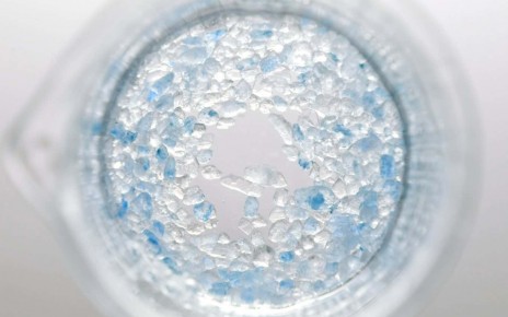 salt crystals dissolving in beaker with water