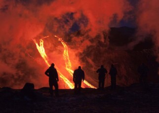 FIMMVORDUHALS, ICELAND - MARCH 24: Hikers are silhouetted against rivers of lava flowing from a volcanic eruption between the Myrdalsjokull and Eyjafjallajokull glaciers on March 24, 2010 in Fimmvorduhals, Iceland. A major eruption occured on April 14, 2010 which has resulted in a plume of volcanic ash being thrown into the atmosphere over parts of Northen Europe. Air traffic has been subject to cancellation or delay as airspace across parts of Northern Europe has been closed. (Photo by Helen Maria Bjornsd/NordicPhotos/Getty Images)
