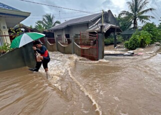 TOPSHOT - A man wades through floodwaters brought about by heavy rains at a residential neighbourhood in Propseridad town, Agusan del Sur province on southern Mindanao island on February 1, 2024. Floods and landslides triggered by torrential rain have killed six people in the Philippines, with one other person missing, rescuers said February 1. (Photo by Erwin MASCARINAS / AFP) (Photo by ERWIN MASCARINAS/AFP via Getty Images)