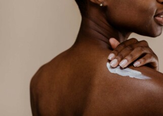 Woman applying body cream to her skin