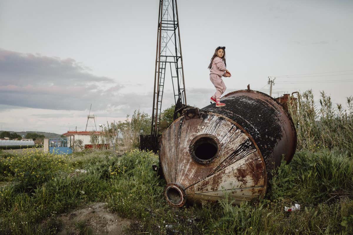 Photographer Name: Jonas Kak? Image Name: Untitled Year: 2024 Image Description: A girl climbs on an old oil tank near a defunct oil well in the village of Zharr?z. Series Name: Black Gold Series Description: Albania is one of the poorest European countries, with a per capita income of US$4,500. Yet it has a subsoil that is rich in crude oil, with more than 5.3 billion barrels lying beneath the surface. During the communist dictatorship of Enver Hoxha, the country was isolated, leaving it open only to Soviet and Chinese influences. These relationships led to the development of the technological capabilities necessary to begin tapping into Albania?s oil wells, but since the fall of the regime, free market capitalism has taken hold. Now, various corporations, including Bankers Petroleum, a Canadian company recently acquired by China?s Geo-Jade Petroleum, own 95 percent of crude oil extraction in the Patos-Marzina region. This seismic shift in the market has caused significant social and environmental issues, including contaminated lakes, oil leaks, abandoned structures, the poisoning of underground water wells and emissions that affect the surrounding villages. Copyright: ? Jonas Kak?, Germany, Shortlist, Professional competition, Environment, Sony World Photography Awards 2024