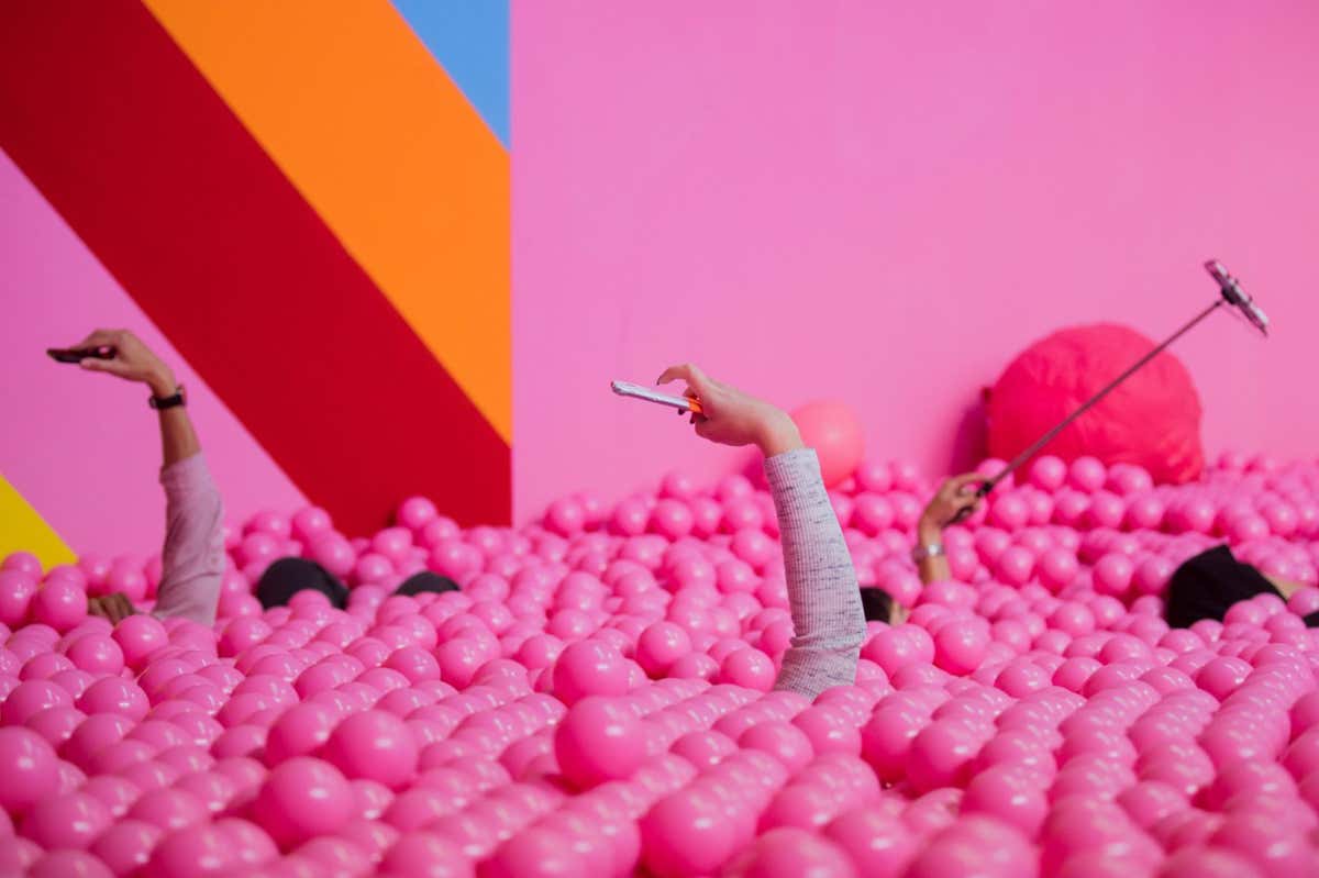 PPN7WJ Cologne, Germany. 27th Sep 2018. 27 September 2018, North Rhine-Westphalia, Cologne: Visitors to the Supercandy Pop-Up Museum make selfies in a ball bath. Until 30.12.2018 the 20 walk-in installations can be seen and experienced in the "Made-for-Instagram" exhibition in Cologne-Ehrenfeld. Photo: Rolf Vennenbernd/dpa Credit: dpa picture alliance/Alamy Live News